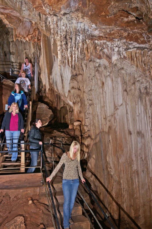 Visitors descending past limestone formations inside Mercer Caverns