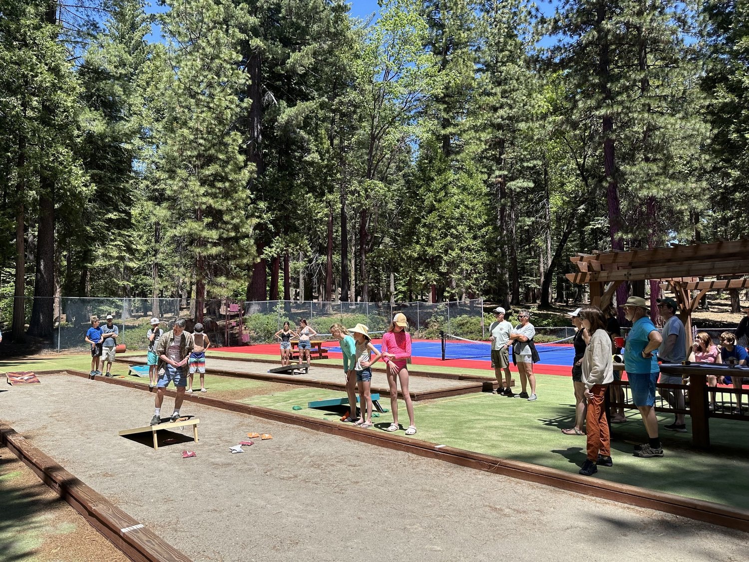 Cornhole games at Big Trees Village Recreation Center, with pickleball courts behind