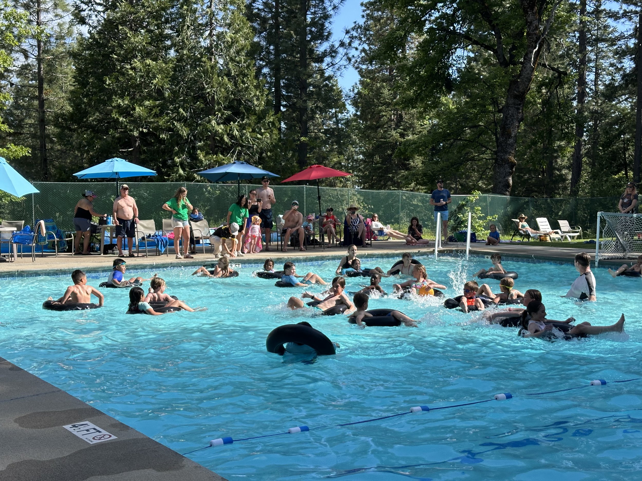Swimmers floating on inner tubes in the Big Trees Village Recreation Center pool